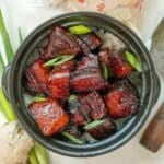 Hong Shao Rou (Chinese Red Braised Pork) in a black pot with rice.