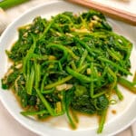Korean spinach side dish prepared on a plate with chopsticks.