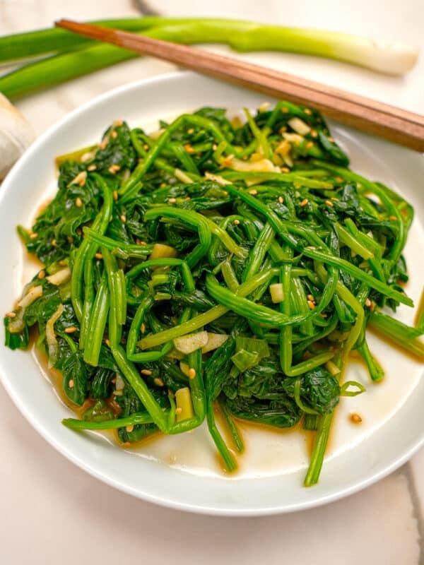 Korean spinach side dish prepared on a plate with chopsticks.