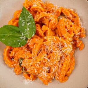 Spicy Vodka pasta in a bowl with basil and parmesan cheese.