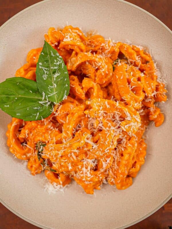 Spicy Vodka pasta in a bowl with basil and parmesan cheese.