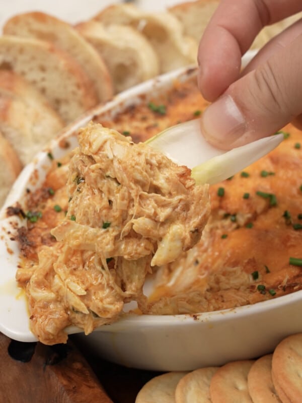 scooping baked crab dip in the pan