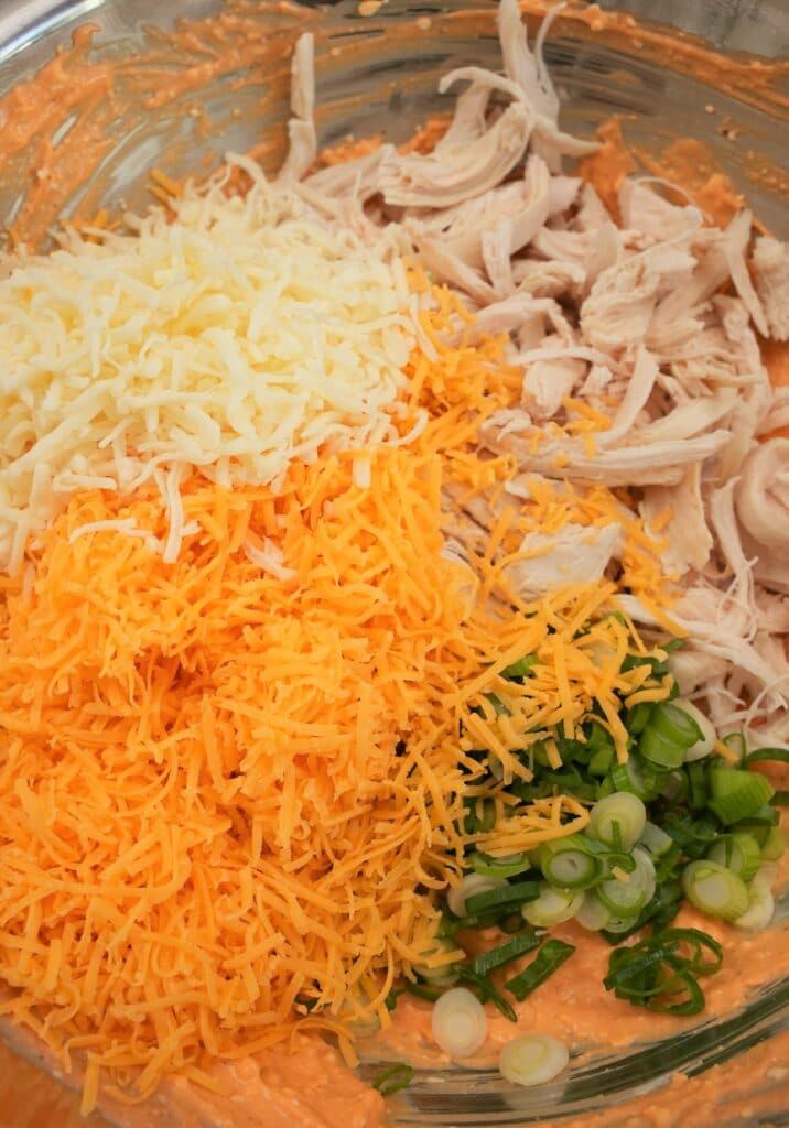 Shredded chicken with cheese and scallions in a bowl