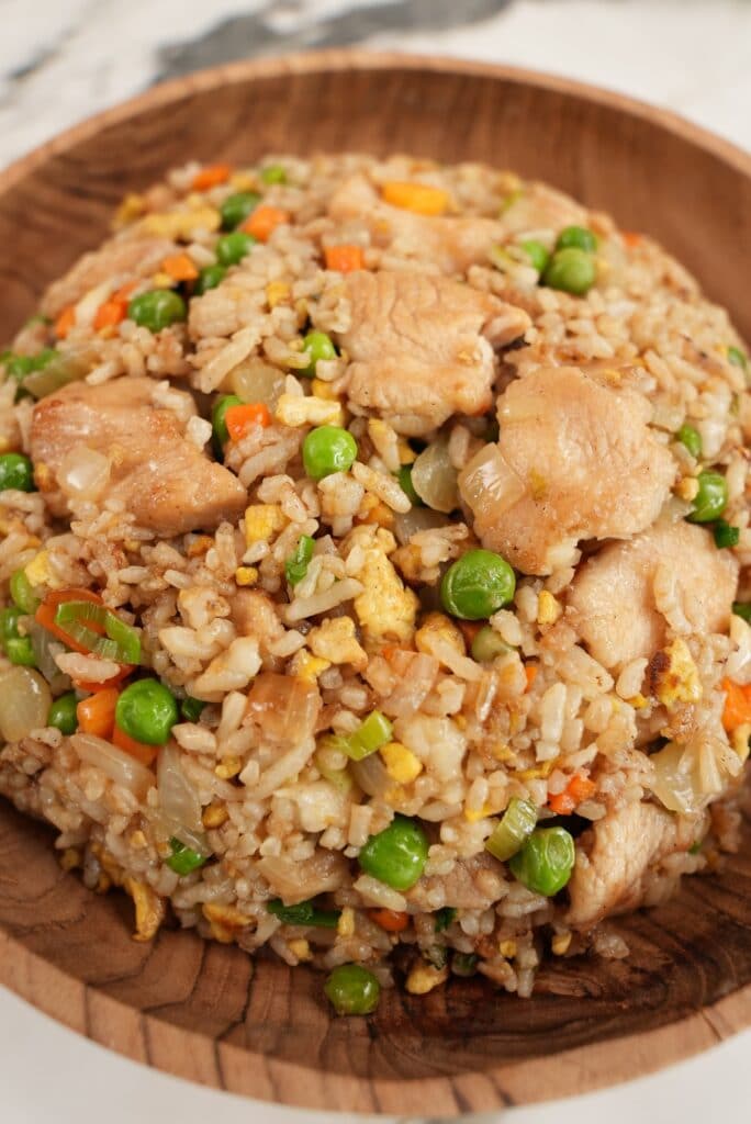 Chicken Fried rice plated in a wooden bowl.