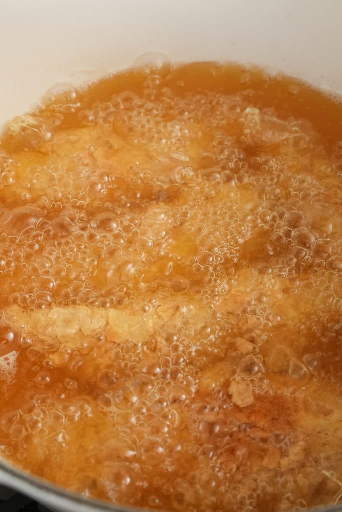 Korean Fried Chicken frying in a pot.