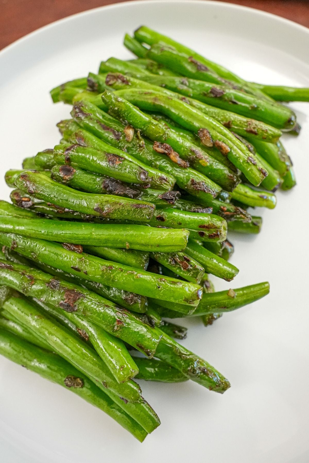 Dry Fried Garlic Green Beans on a white plate.