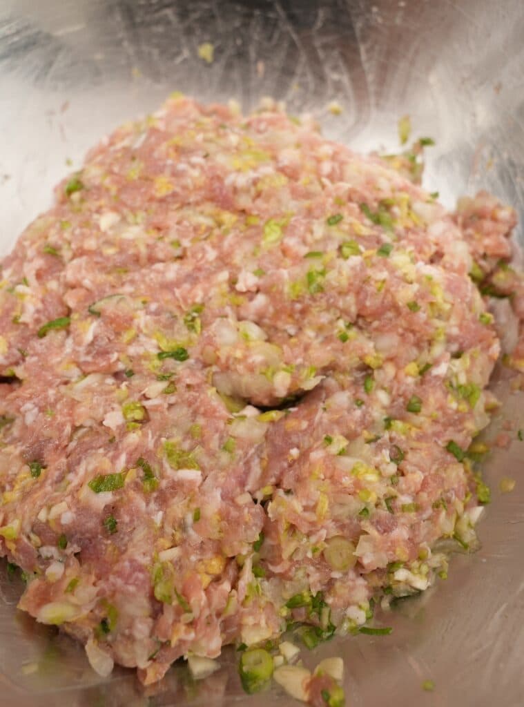 Pork dumpling filling mixed in a metal bowl.