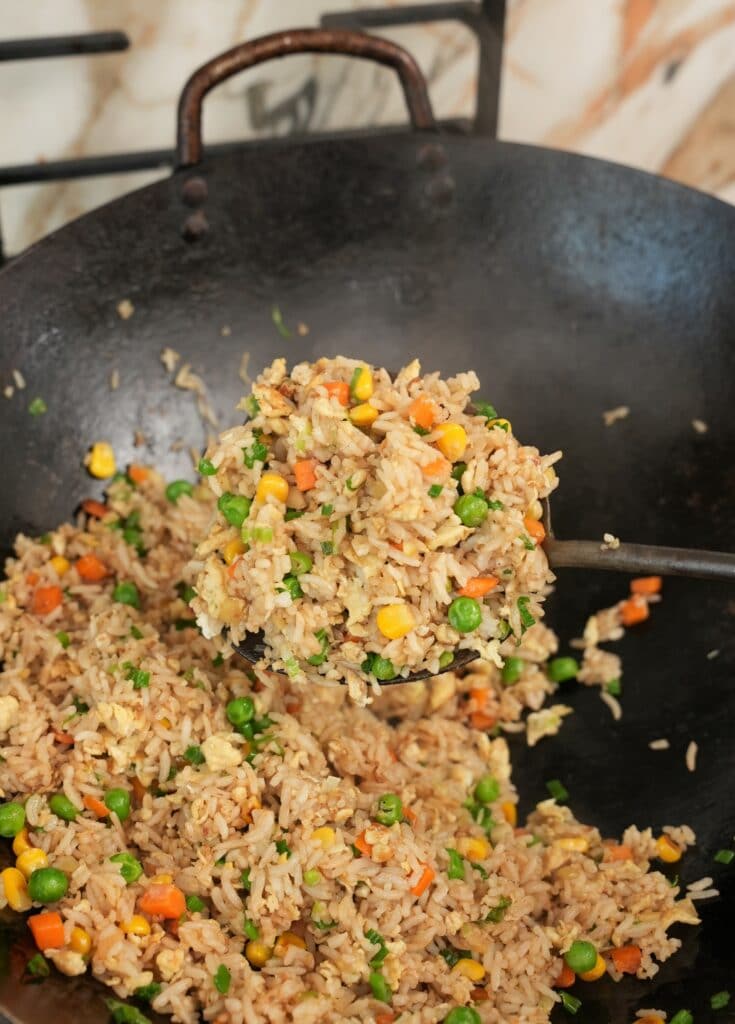 Egg Fried Rice on a wok ladle in a wok