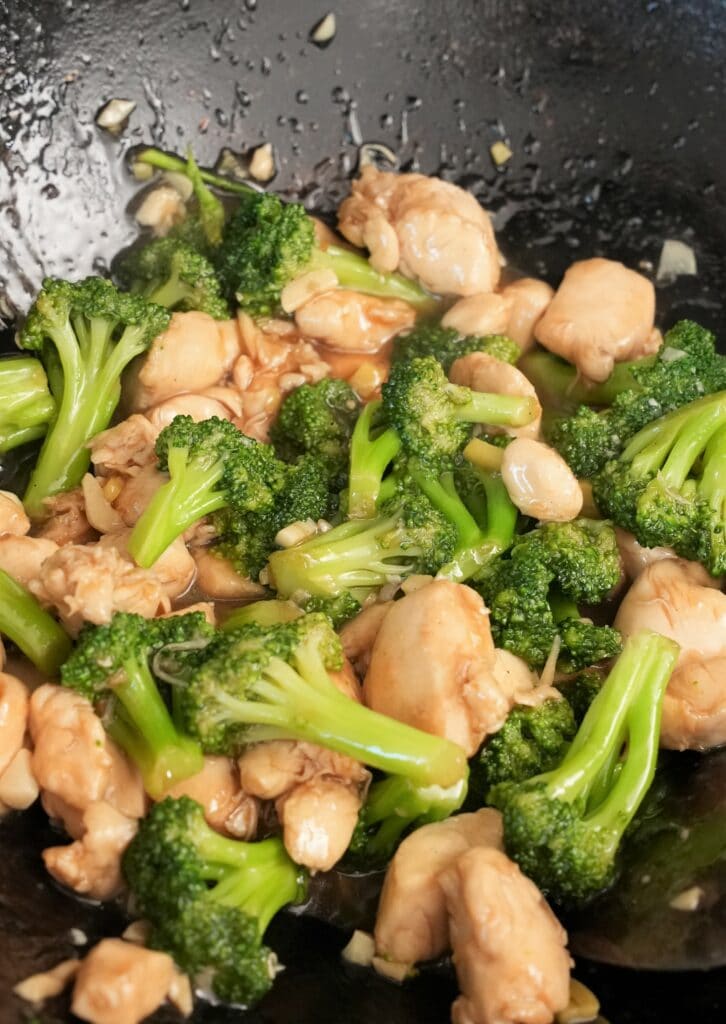 Chinese Chicken and Broccoli mixed with sauce and cooked in a wok.