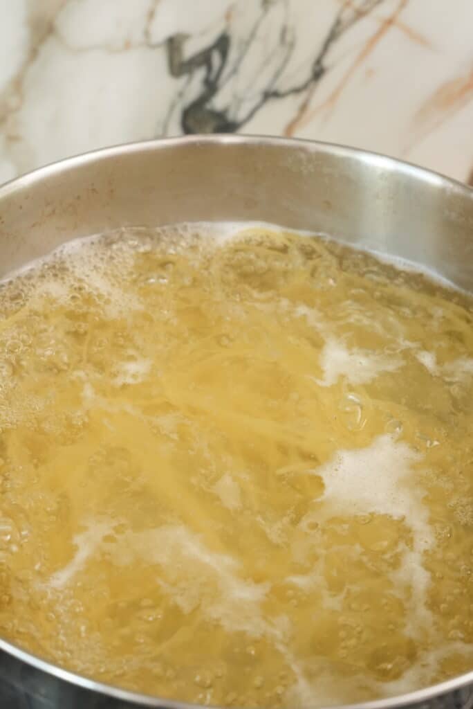 Fettuccine pasta boiling in a pot of water.