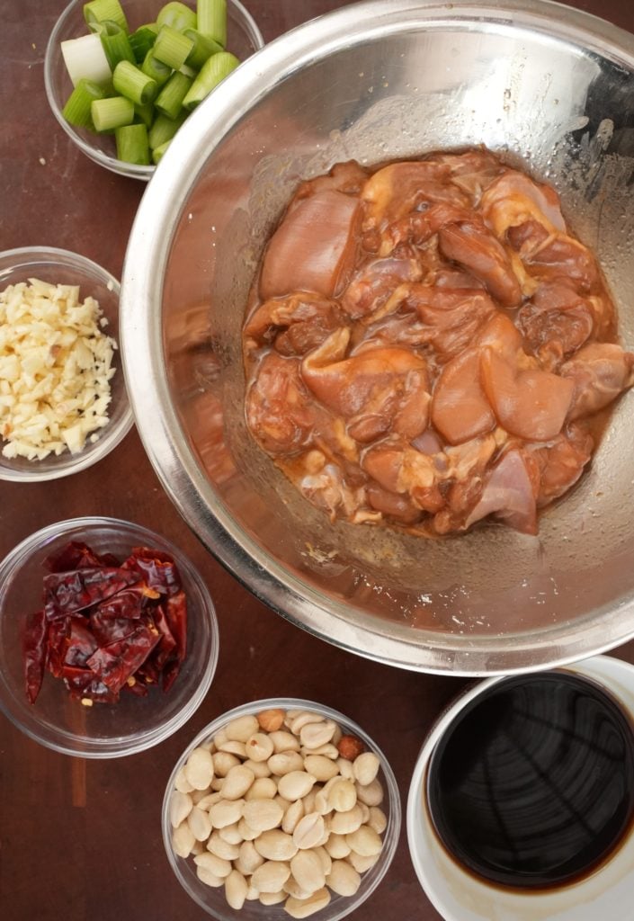 Raw ingredients for Kung Pao Chicken in bowls on a cutting board.