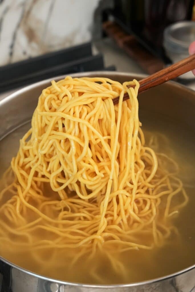 Egg noodles cooking in boiling water.