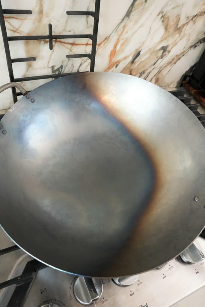 a top down view of a partially seasoned wok on a stove