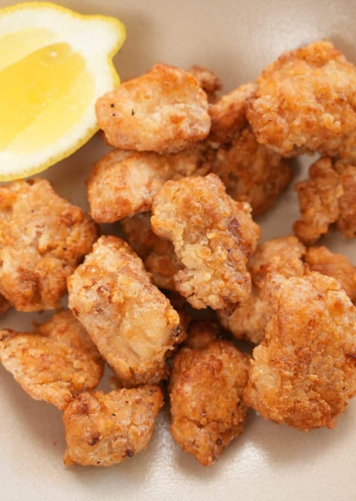 Close up of air fryer chicken karaage on a plate with lemon