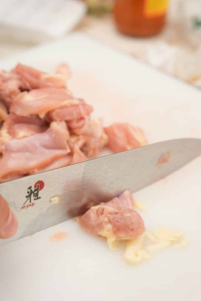 Cutting chicken on a cutting board