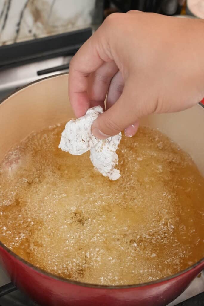 Frying chicken pieces in a dutch oven
