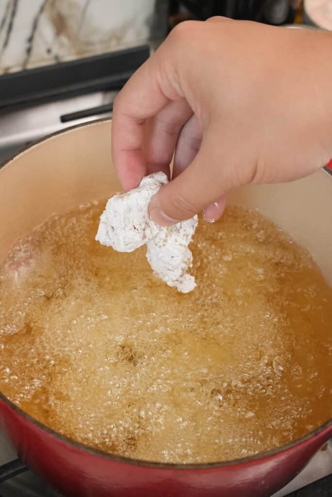 Frying chicken pieces in a dutch oven.