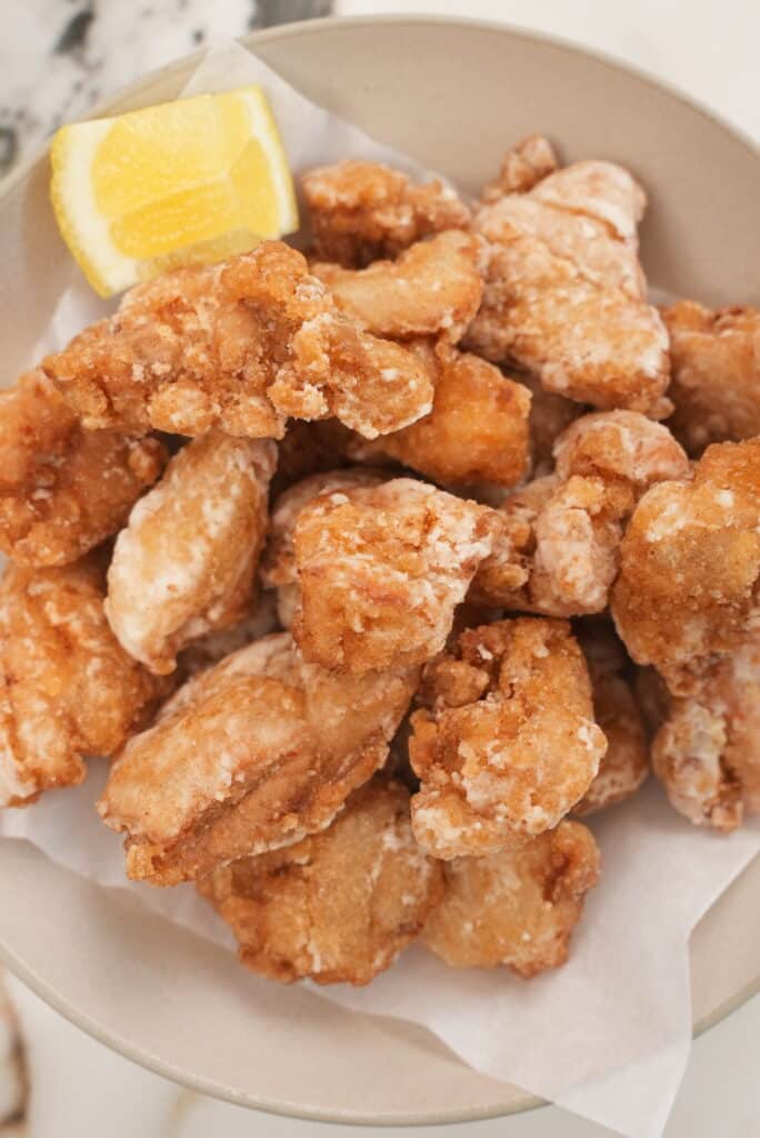 A plate of Japanese fried chicken with lemon.