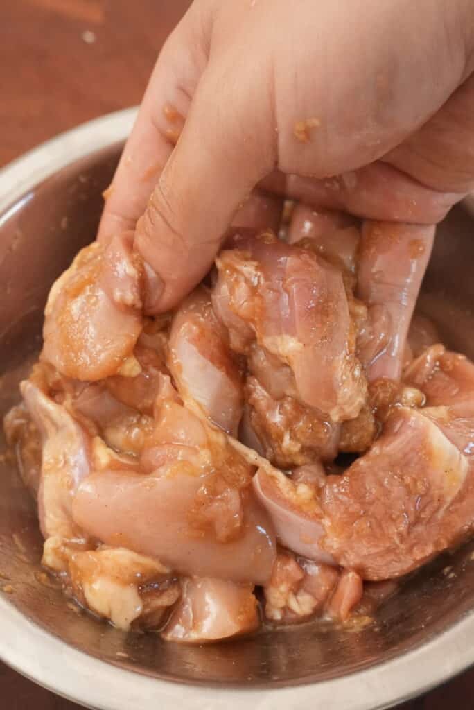 Marinated chicken in a bowl with soy sauce, sake, garlic, and ginger