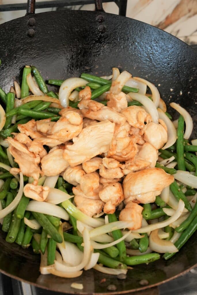 Chicken cooking with string beans and onions