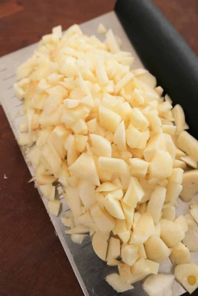 raw garlic chopped on a cutting board