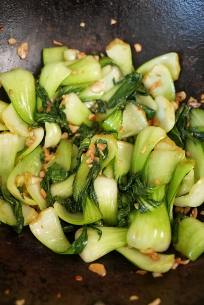 Garlic bok choy cooked in a wok.