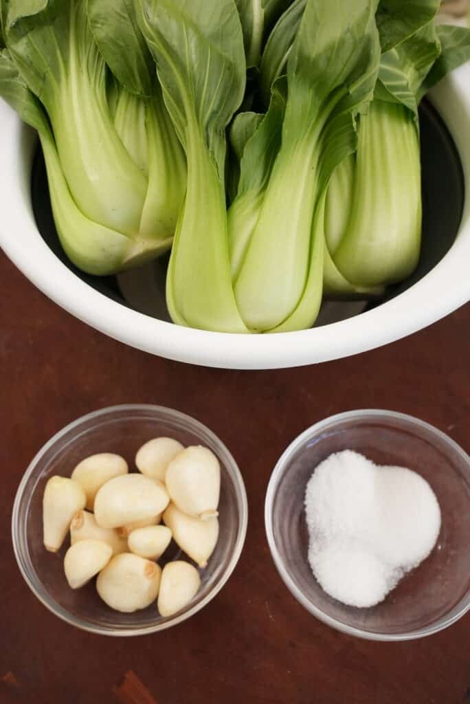 Garlic bok choy raw ingredients on a cutting board.