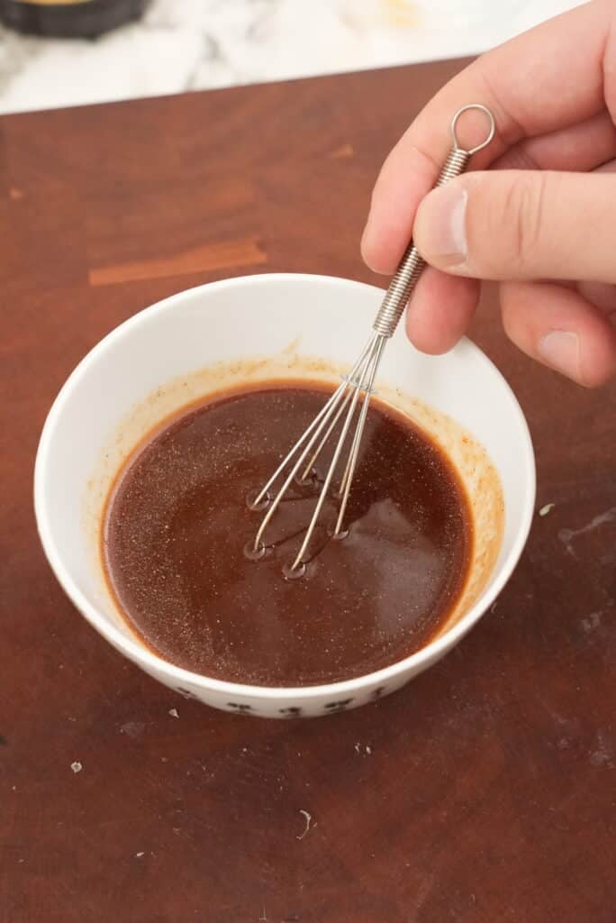 Mixing Spicy Garlic Ramen sauce in a bowl.