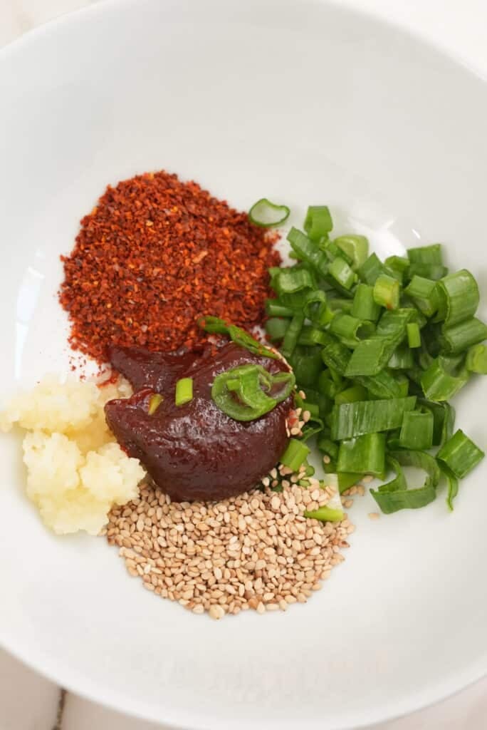 Raw ingredients for spicy gochujang noodles in a bowl.