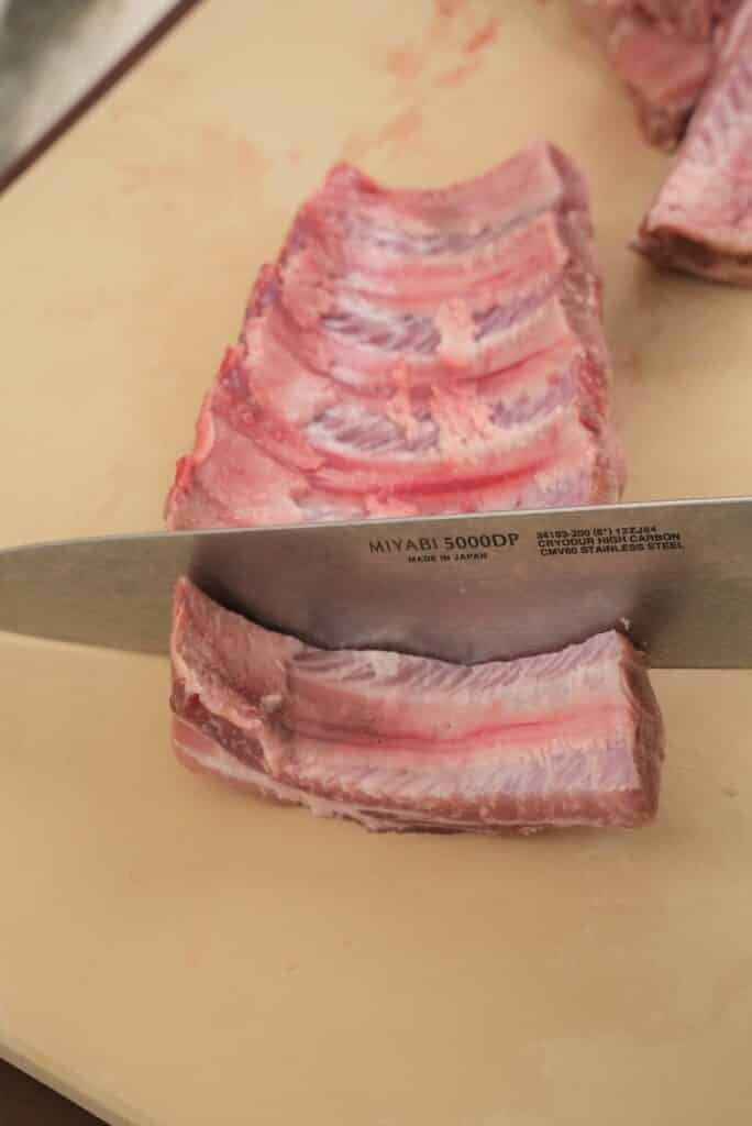 slicing a slab of ribs into single ribs