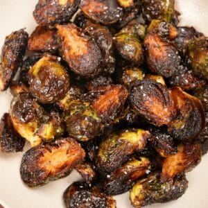 Crispy roasted brussels sprouts in a ceramic bowl.