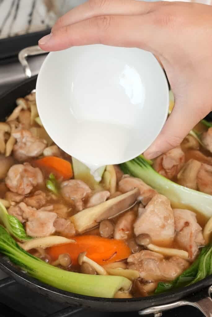 adding cornstarch slurry to gravy in pan