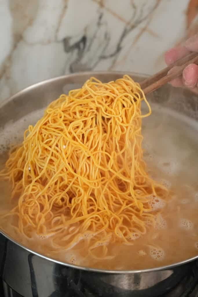 Blanching chow mein noodles.