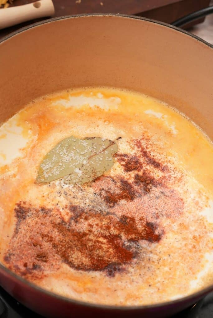 adding spices to cheese sauce