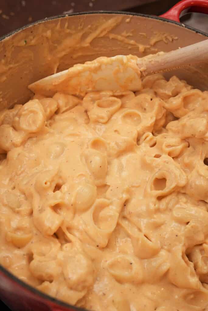 https://cjeatsrecipes.com/wp-content/uploads/2022/11/Macaroni-and-cheese-mixing-pasta-with-sauce-684x1024.jpg