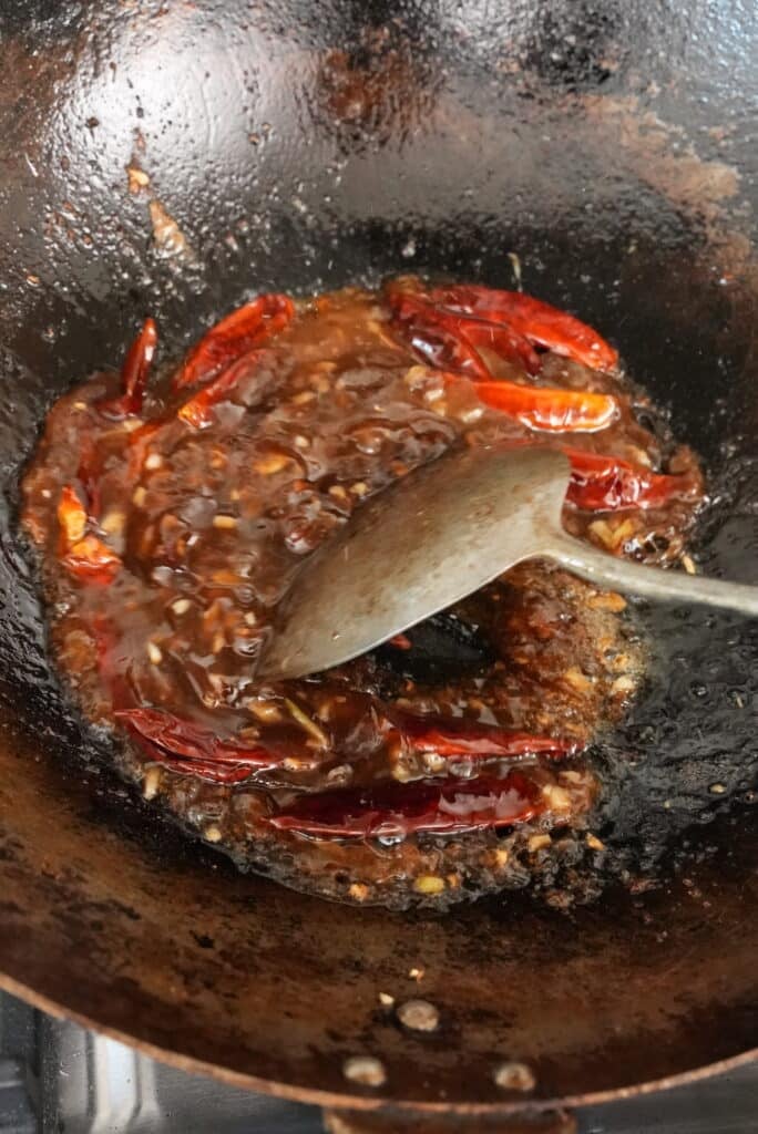 Mongolian beef sauce mixing in a wok.