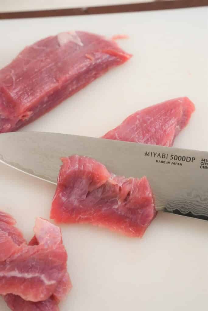 Cutting steak with a knife against the grain.