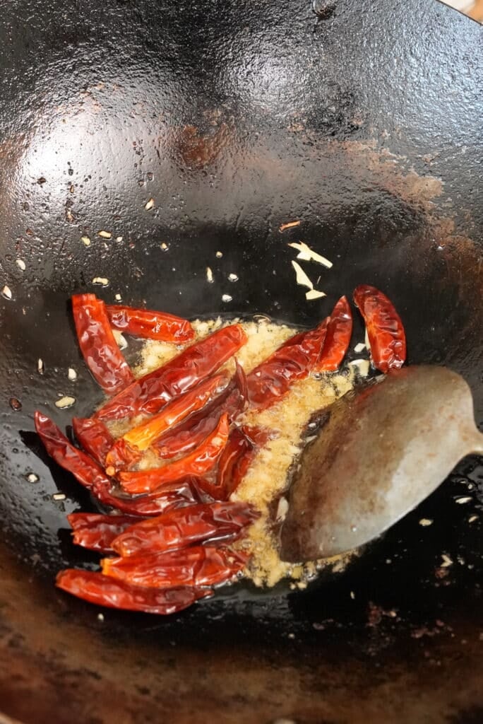 frying aromatics and chilis in a wok.