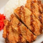Crispy Air Fryer Chicken Katsu in a bowl with rice, tonkatsu sauce, and pickled radish.