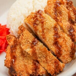 Crispy Air Fryer Chicken Katsu in a bowl with rice, tonkatsu sauce, and pickled radish.