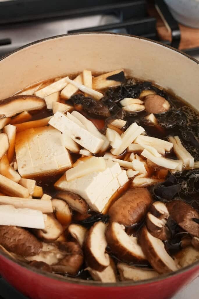 Mushrooms and tofu added to a pot