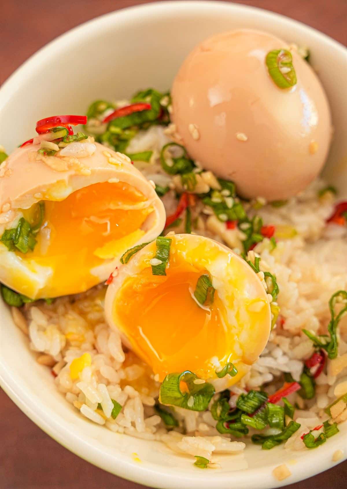 Korean Marinated Eggs (Mayak Eggs) over rice in a bowl.