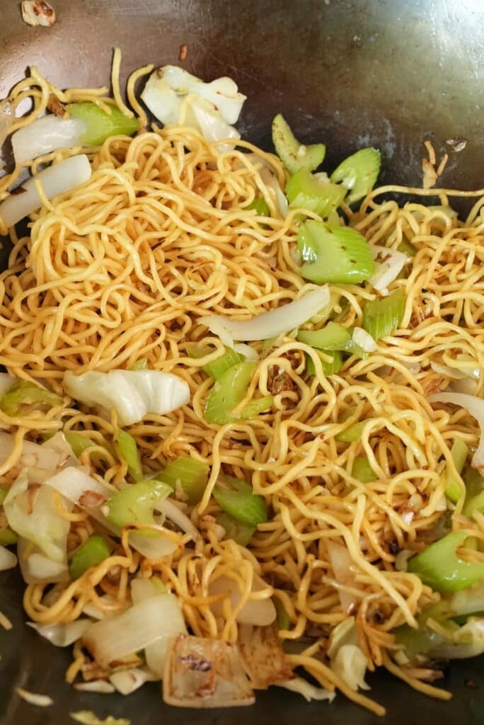 Stir fried chow mein noodles in a wok with vegetables