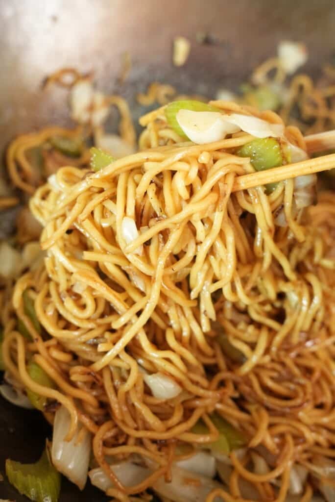 Panda express chow mein in a wok lifted with chopsticks