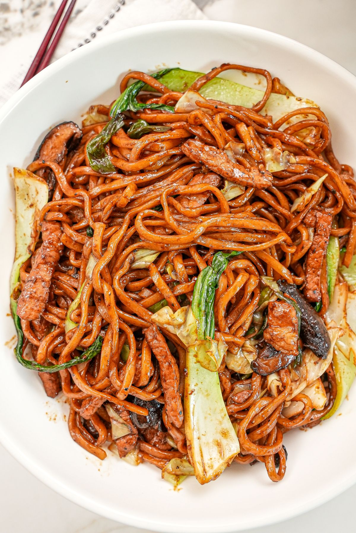 A bowl of Shanhai Fried Noodles in a bowl with bok choy, mushrooms, and pork.