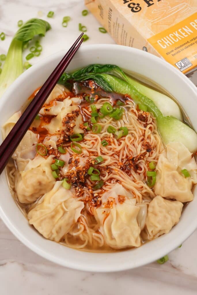 Wonton Noodle Soup in a bowl with bok choy and chili oil.