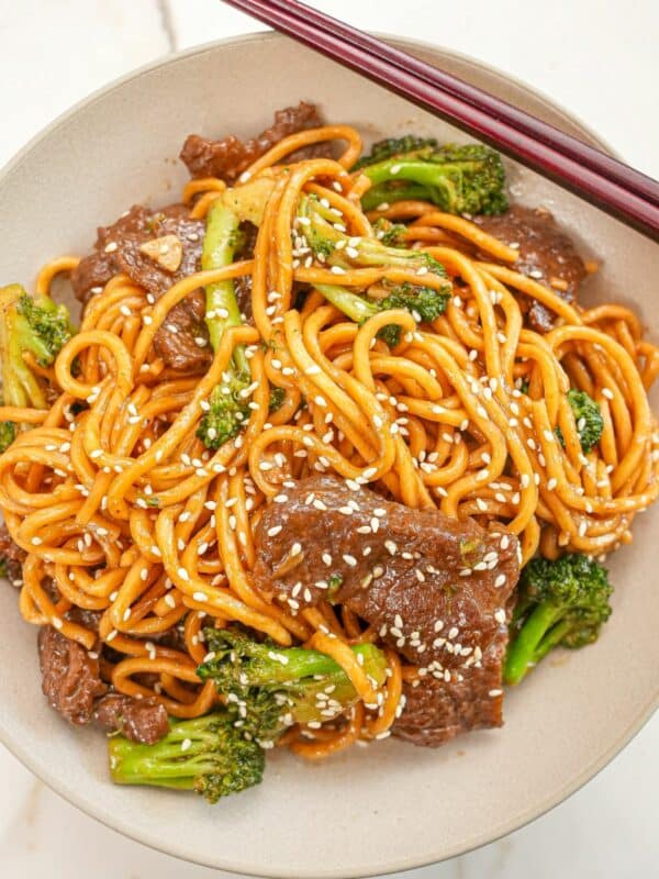 Beef and Broccoli Noodles in a bowl with chopsticks.