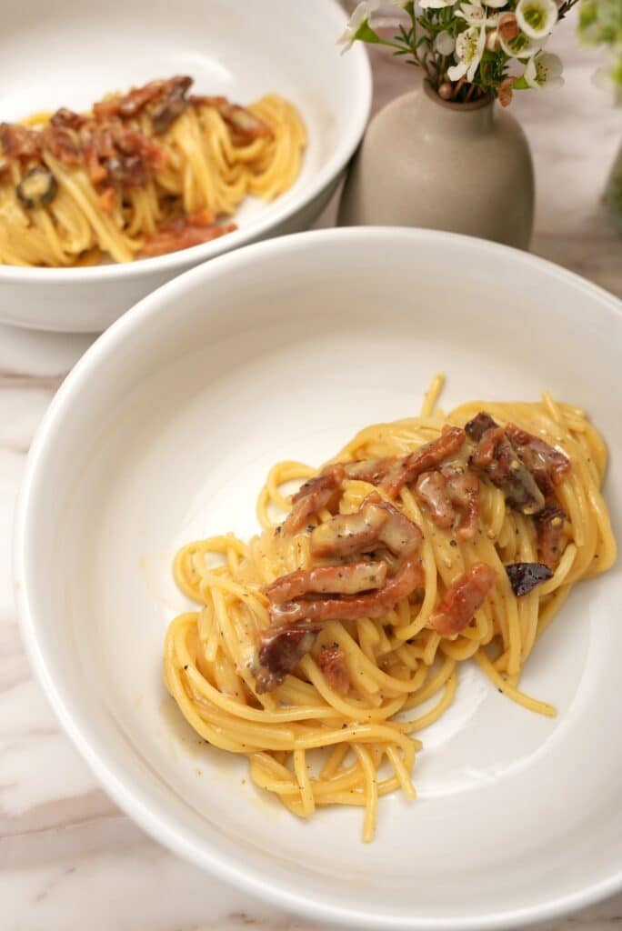 two bowls of carbonara on a table
