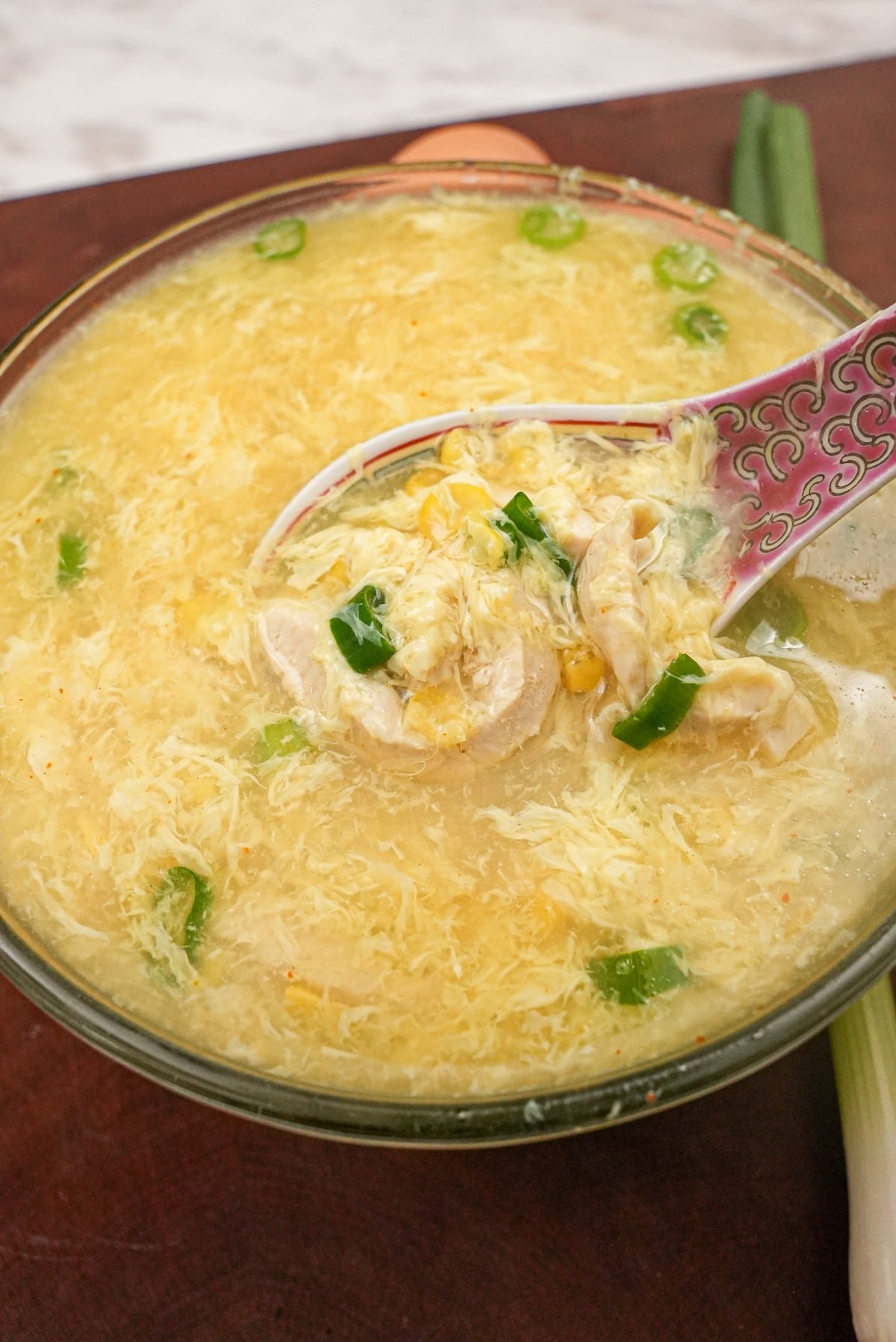 Chicken Corn Egg Drop Soup in a bowl with a spoon.