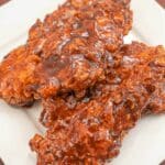 A plate of Korean Honey Butter Fried Chicken stacked on top of each other.